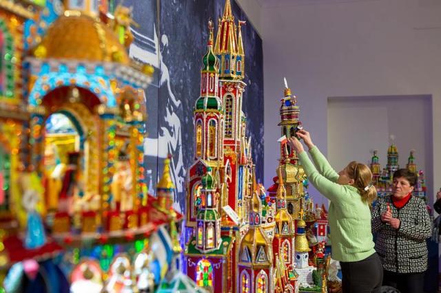 Two woman installing the colorful nativity scene