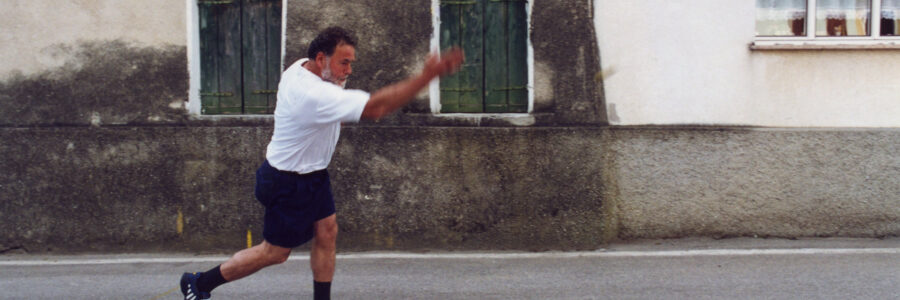 A man throwing a ball in the streets of Mel